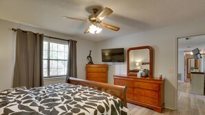 A bedroom with a bed, a ceiling fan, a dresser, a television, and a mirror. - Pet-friendly Slocomb Vacation Rental w/ Sunroom! (Slocomb)