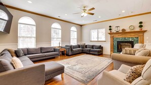 A spacious living room with a sectional sofa, a beige armchair, and a fireplace. - Spacious Hildale House w/ Large Deck! (Hildale)