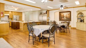 A spacious kitchen with wooden cabinets, a central island, and a dining area with a round table and chairs. - Spacious Hildale House w/ Large Deck! (Hildale)