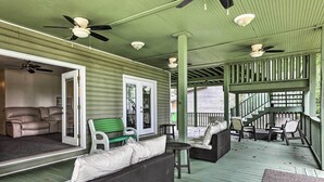 A covered porch with outdoor furniture, ceiling fans, and a staircase leading to an upper level. - Spacious Family Home on Lake Marion w/ Boat Ramp! (Cameron)