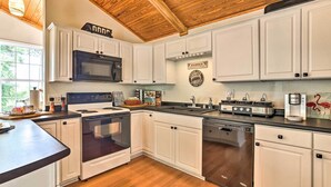 A kitchen with white cabinets, a microwave, stove, and dishwasher. - Spacious Family Home on Lake Marion w/ Boat Ramp! (Cameron)