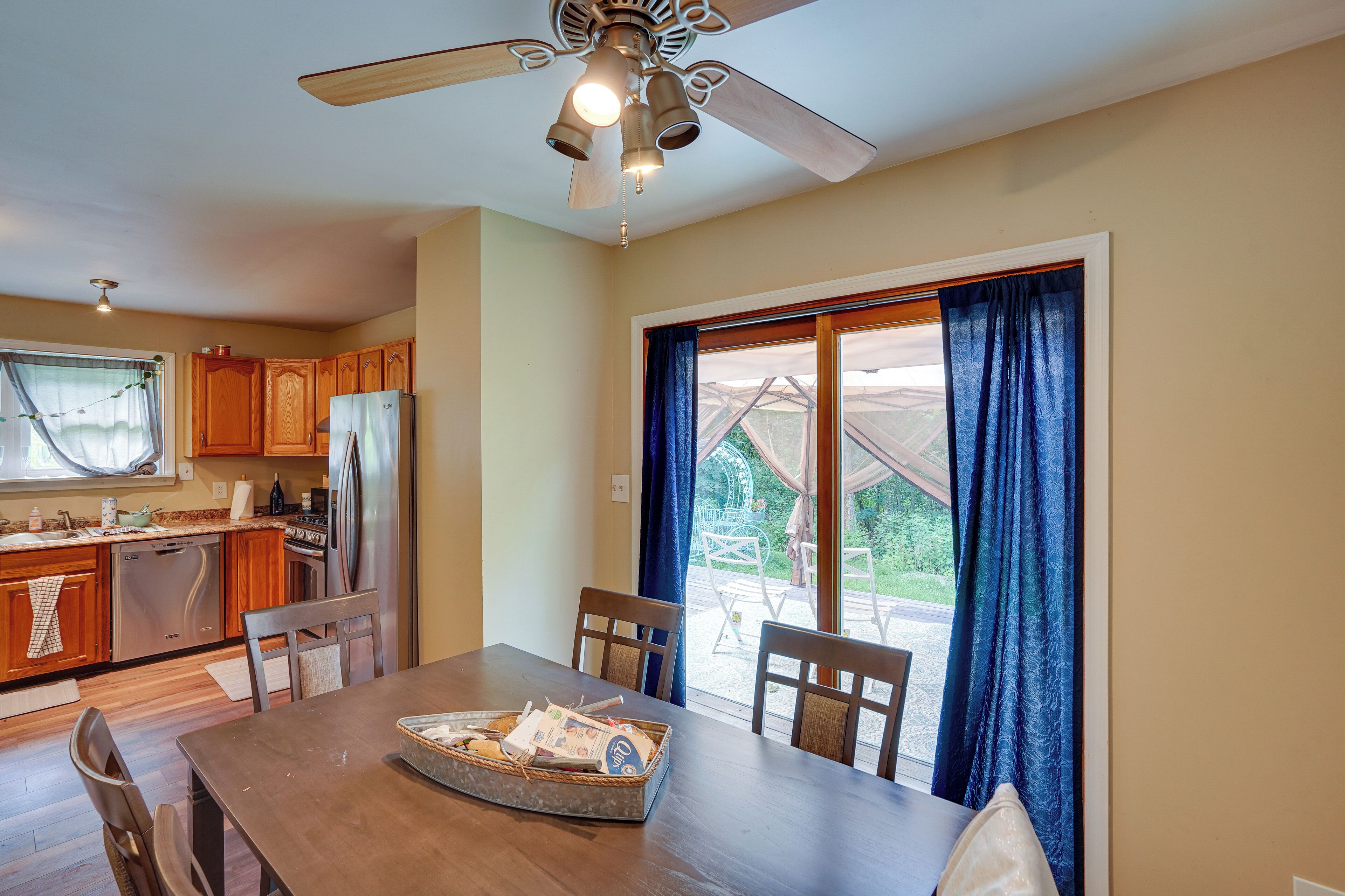 A kitchen with wooden cabinets, a refrigerator, and a dining table with chairs.