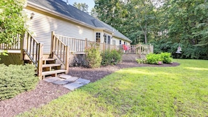 A house with a wooden deck, a stone pathway, and a well-maintained lawn. - Charming Flushing Cottage w/ Deck + Spacious Yard! (Flushing)