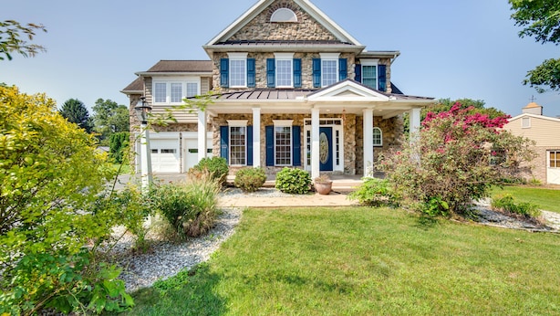A two-story house with a stone facade, blue shutters, and a front porch. - Charming Pennsylvania Retreat w/ Deck & Fireplace! (Willow Street)