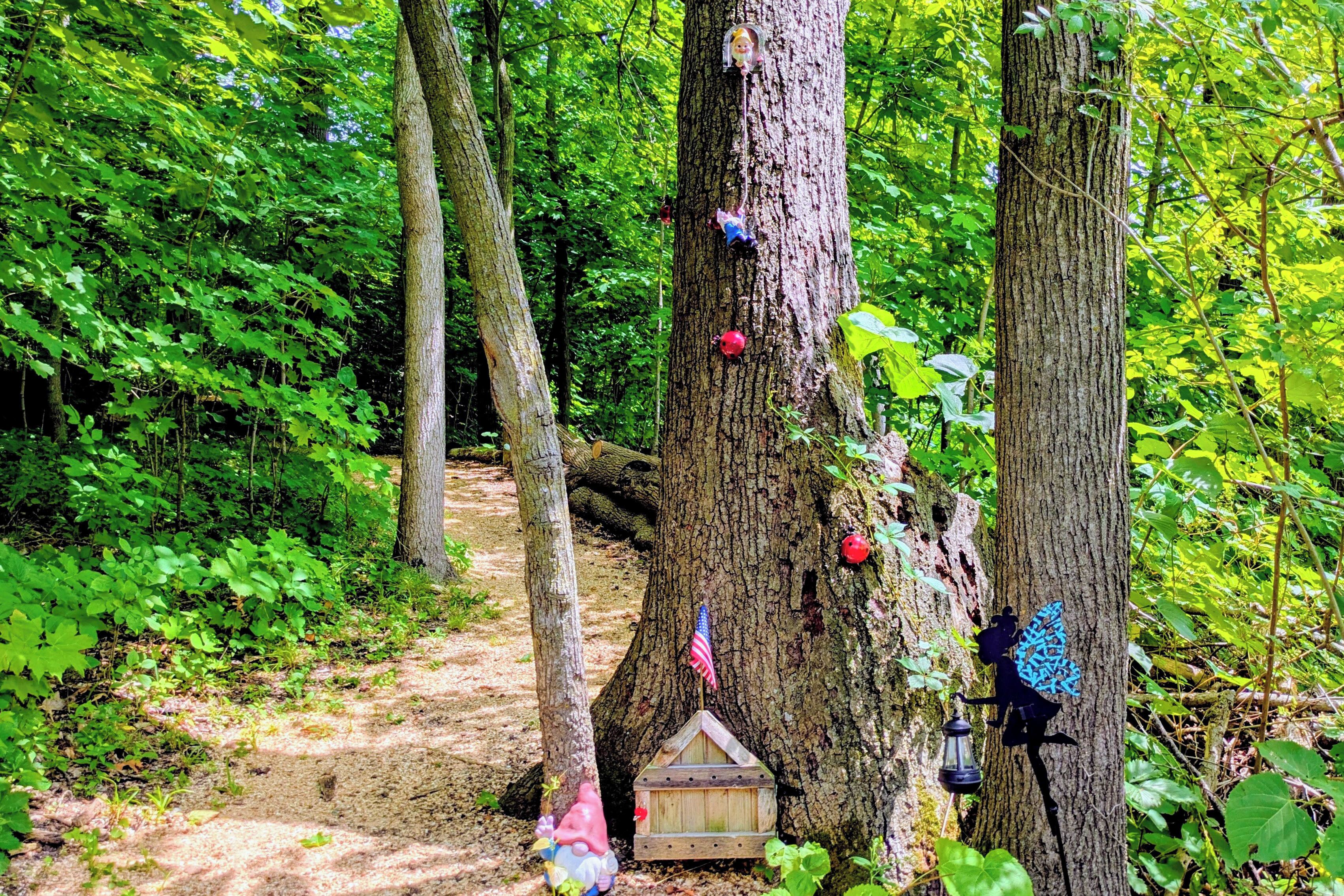 A forest scene with a wooden birdhouse, a lantern, and a small American flag.