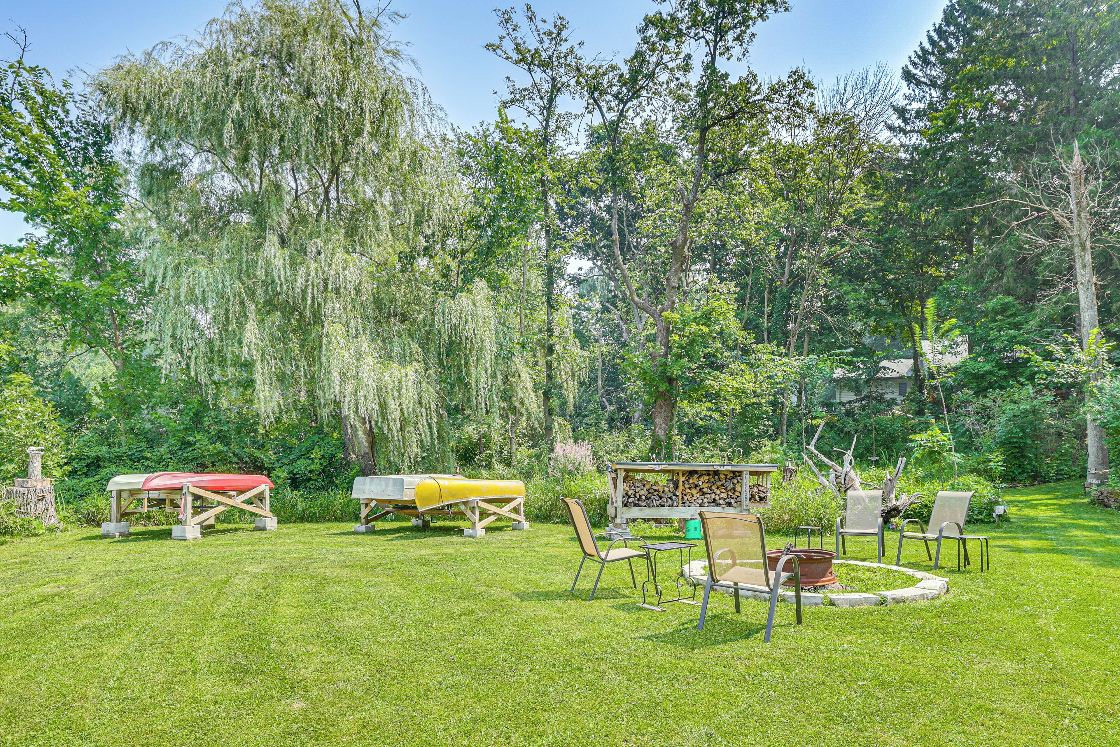 Un jardin bien entretenu, équipé d’une table de pique-nique, de chaises et d’une petite structure en bois.