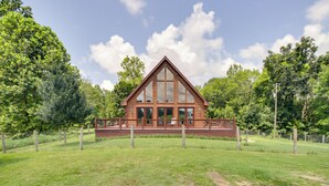 A wooden cabin with a triangular roof, large windows, and a fenced yard. - 12 Mi to Staunton River: Nathalie Cabin w/ Deck (Nathalie)