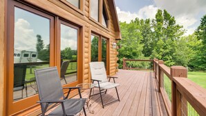 A wooden deck with two chairs and a table, overlooking a grassy area and trees. - 12 Mi to Staunton River: Nathalie Cabin w/ Deck (Nathalie)
