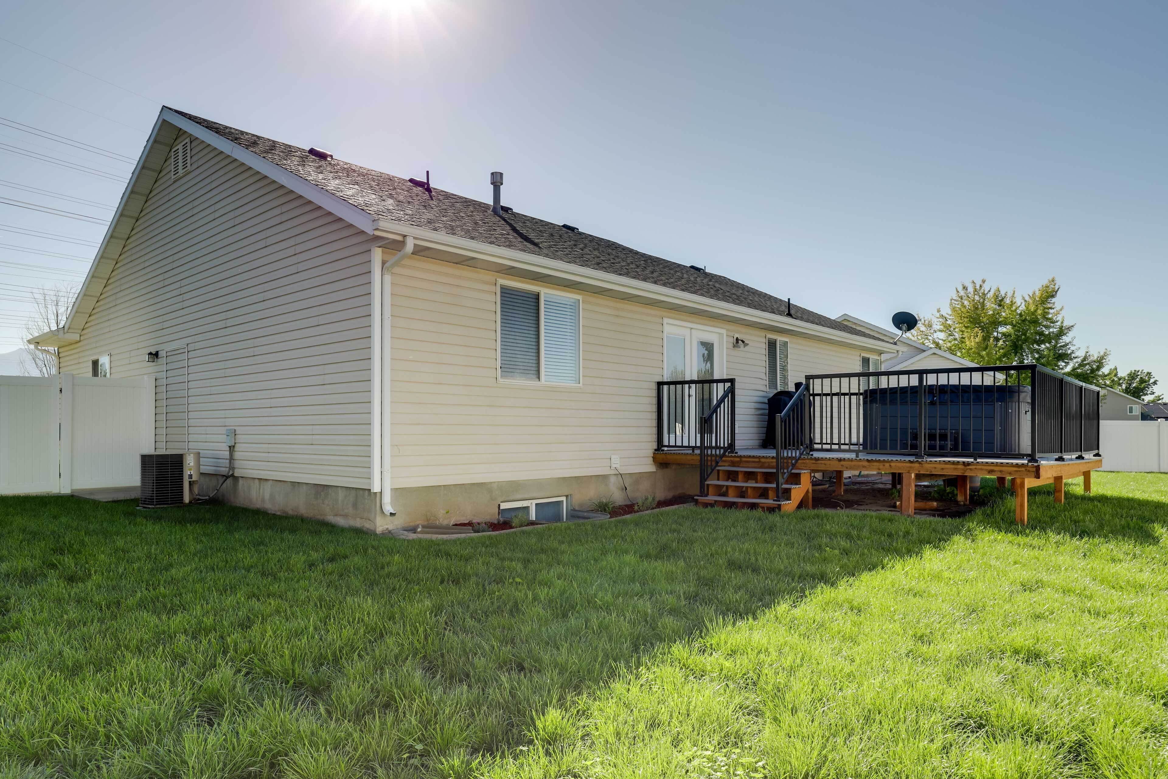 A single-story house with a fenced yard, a deck, and a satellite dish.