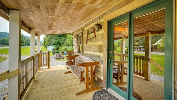 A wooden porch with a bench and tables, a door with a green frame, and a view of the surrounding landscape. - Historic Cabin Retreat ~ 2 Mi to Seneca Rocks! (Seneca Rocks)