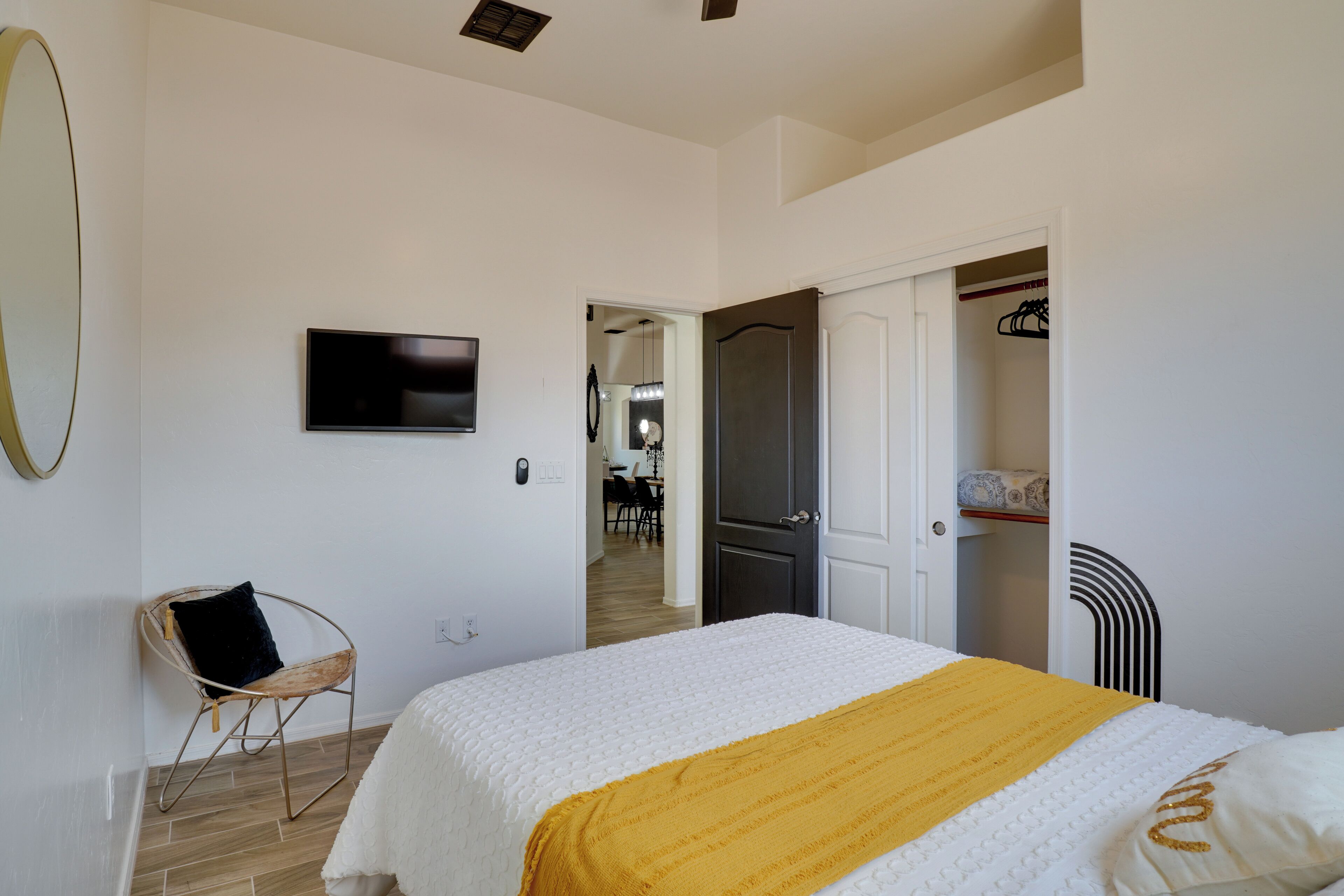 Een slaapkamer met een bed, een stoel, een televisie en een kledingkast.
