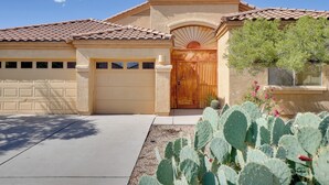 A residential house with a garage, a wooden front door, and a cactus in the front yard. - 14 Mi to Dtwn: Tucson Escape w/ Patio! (Tucson)