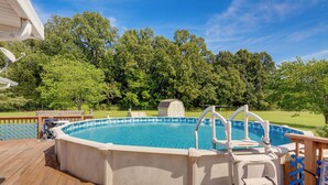 An above-ground swimming pool with a wooden deck, a diving board, and a hot tub. - Cozy Stafford Home w/ Outdoor Pool: Pets Welcome! (Strafford)