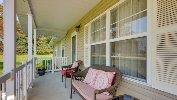 A covered porch with wicker furniture and a potted plant. - Cozy Stafford Home w/ Outdoor Pool: Pets Welcome! (Strafford)