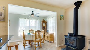 A dining area with wooden chairs and a table, a black stove, and a clock on the wall. - Cozy Stafford Home w/ Outdoor Pool: Pets Welcome! (Strafford)