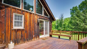 A wooden cabin with a deck, large windows, and a bench. - Historic Morrisdale Area Cabin w/ Deck & Fireplace (Morrisdale)