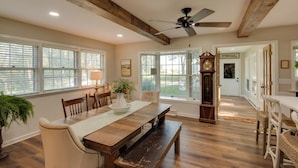 A spacious dining area with a wooden table, chairs, and a ceiling fan. - Charming Villisca Getaway w/ Screened Porch! (Villisca)