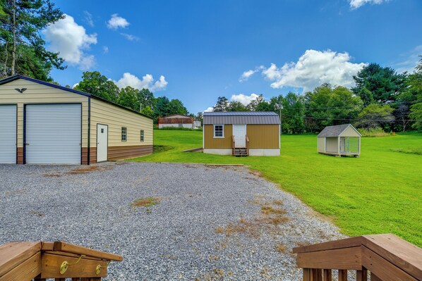 A gravel driveway leading to a house with a garage, a small shed, and a wooden bench. - Dog-friendly Home w/ Mtn Views in Chilhowie! (Chilhowie)