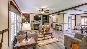 A spacious living room with a fireplace, a ceiling fan, and a dining area with a table and chairs. - Dog-friendly Home w/ Mtn Views in Chilhowie! (Chilhowie)