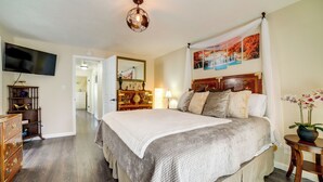 A bedroom with a large bed, a television, a dresser, and a mirror. - Pet-friendly Home w/ Hot Tub! 6 Mi to Dtwn Reno (Reno)