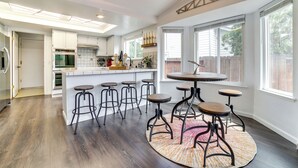 A modern kitchen with a central island, bar stools, and large windows. - Pet-friendly Home w/ Hot Tub! 6 Mi to Dtwn Reno (Reno)