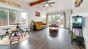 A spacious living room with a sofa, a coffee table, a dining table with chairs, a ceiling fan, and a fish tank. - Pet-friendly Home w/ Hot Tub! 6 Mi to Dtwn Reno (Reno)