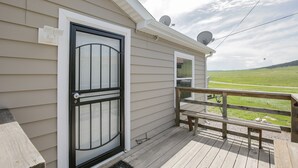 Eine Holzterrasse mit einer Bank und einer Tür mit Glasfenster.