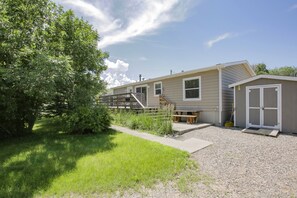 A mobile home with a covered patio, a small deck, and a shed. - Fort Smith Vacation Rental Near Bighorn River (Fort Smith)