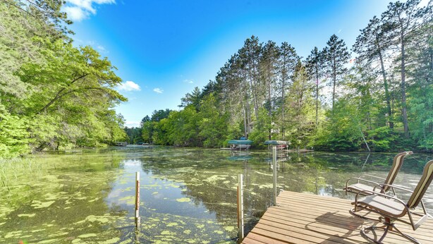 A wooden dock extending into a clear river with a chair on it. - Grill & Fire Pit: Waterfront Cameron Retreat! (Cameron)