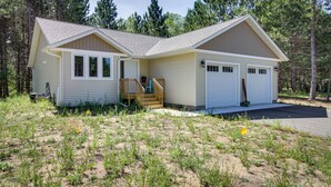 A two-story house with a front porch, a garage, and a yard. - Wadena Vacation Rental ~ 1 Mi to Downtown! (Wadena)