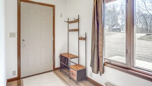 A room with a wooden door, a window with a view of the outside, and a metal shelf unit with drawers. - Riverfront Covington Cabin w/ Deck & Fire Pit! (Covington)