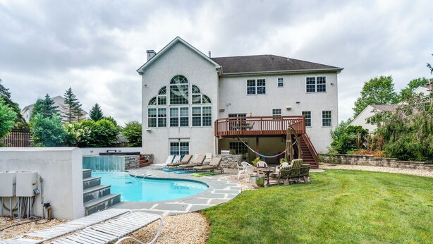 A two-story house with a swimming pool, outdoor seating, and a deck. - Centrally Located Family Home w/ Pool (Harleysville)