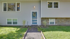 A two-story house with a front porch, a small front yard, and a driveway leading to the entrance. - Kiamesha Lake Home w/ Deck: 4 Mi to Resorts World! (Kiamesha Lake)