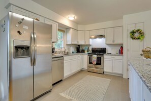 A modern kitchen with white cabinets, stainless steel appliances, and a granite countertop. - Kiamesha Lake Home w/ Deck: 4 Mi to Resorts World! (Kiamesha Lake)
