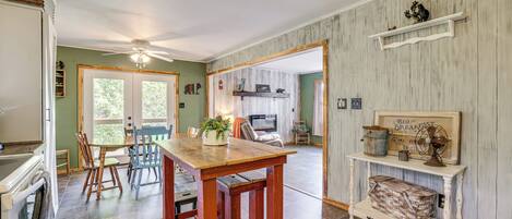 A spacious kitchen with a wooden table and chairs, a dining area with a view, and a rustic wall decor.