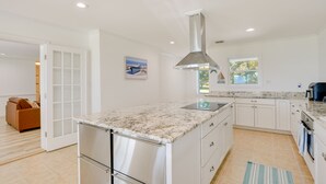 A modern kitchen with white cabinets, a stainless steel refrigerator, and a granite countertop. - Sun-dappled Waterfront Home on Potomac River! (Scotland)