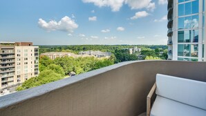 Un balcon offrant une vue sur le paysage urbain, avec des bâtiments et de la verdure.