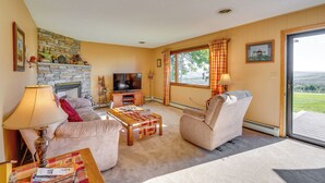 A cozy living room with a stone fireplace, a television, and a comfortable seating area. - Muncy Vacation Rental w/ Deck & Views (Muncy)
