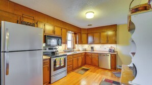 A kitchen with wooden cabinets, a stainless steel refrigerator, a microwave, and a dishwasher. - Muncy Vacation Rental w/ Deck & Views (Muncy)