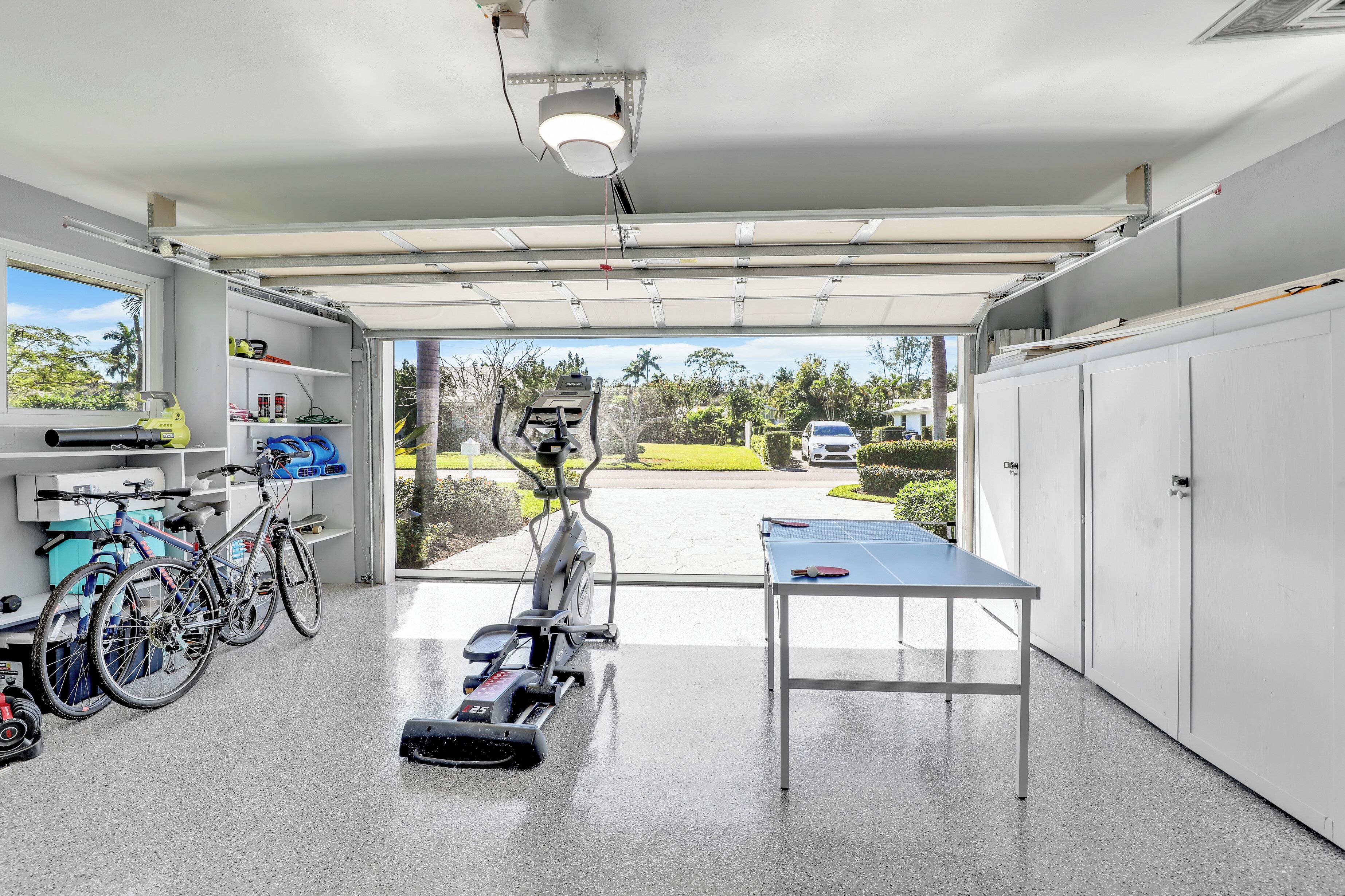 A gym with exercise equipment, a ping pong table, and bicycles.