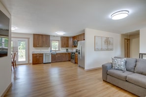 A spacious kitchen with wooden cabinets, a stainless steel refrigerator, and a dining area with a table and chairs.