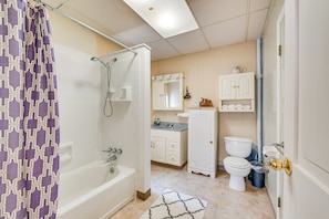 A bathroom with a bathtub, toilet, and sink, featuring a patterned shower curtain and a mirror above the sink. - Condo Rental w/ Pool Access ~ 11 Mi to Allentown! (Bath)
