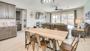 A spacious kitchen with a dining area, a ceiling fan, and a view of the outside. - Tucson 4BR Retreat! Private Pool, Fire Pit! (Tucson)
