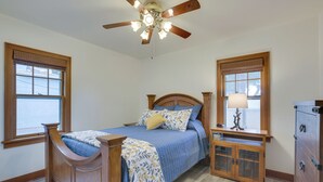A bedroom with a wooden bed, a nightstand, a dresser, and a ceiling fan. - Glendive Getaway w/ Yellowstone River Access! (Glendive)