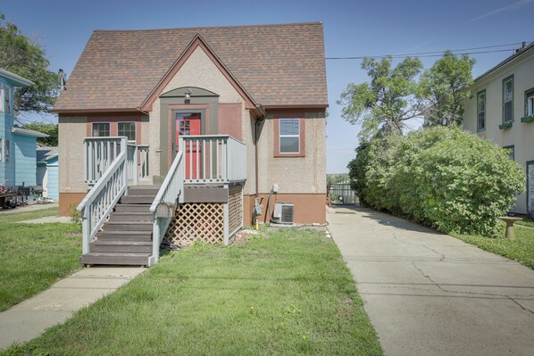 A two-story house with a front porch, a staircase, and a small front yard.