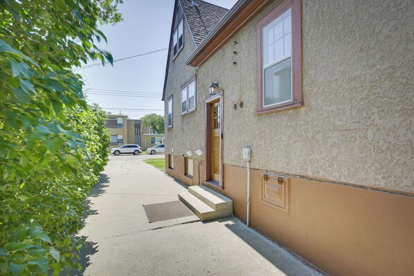 Une maison à deux étages avec une porte d’entrée, un petit porche et un garage.