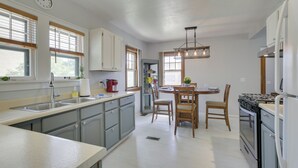 A modern kitchen with a central island, built-in appliances, and ample natural light. - Glendive Getaway w/ Yellowstone River Access! (Glendive)