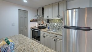 A modern kitchen with granite countertops, stainless steel appliances, and light gray cabinetry. - Pet-friendly Caneadea Retreat With Deck! (Belfast)