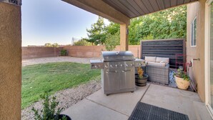 A patio area with a stainless steel grill, outdoor seating, and a view of the backyard. - Chic New Mexico Retreat w/ Patio, Grill & Fire Pit (Los Lunas)