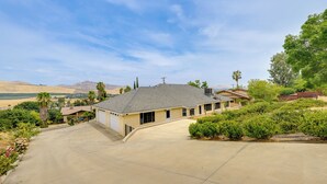 A single-story house with a sloped roof, a garage, and a driveway leading to the front door. - Porterville Getaway w/ Patio + Valley Views! (Porterville)